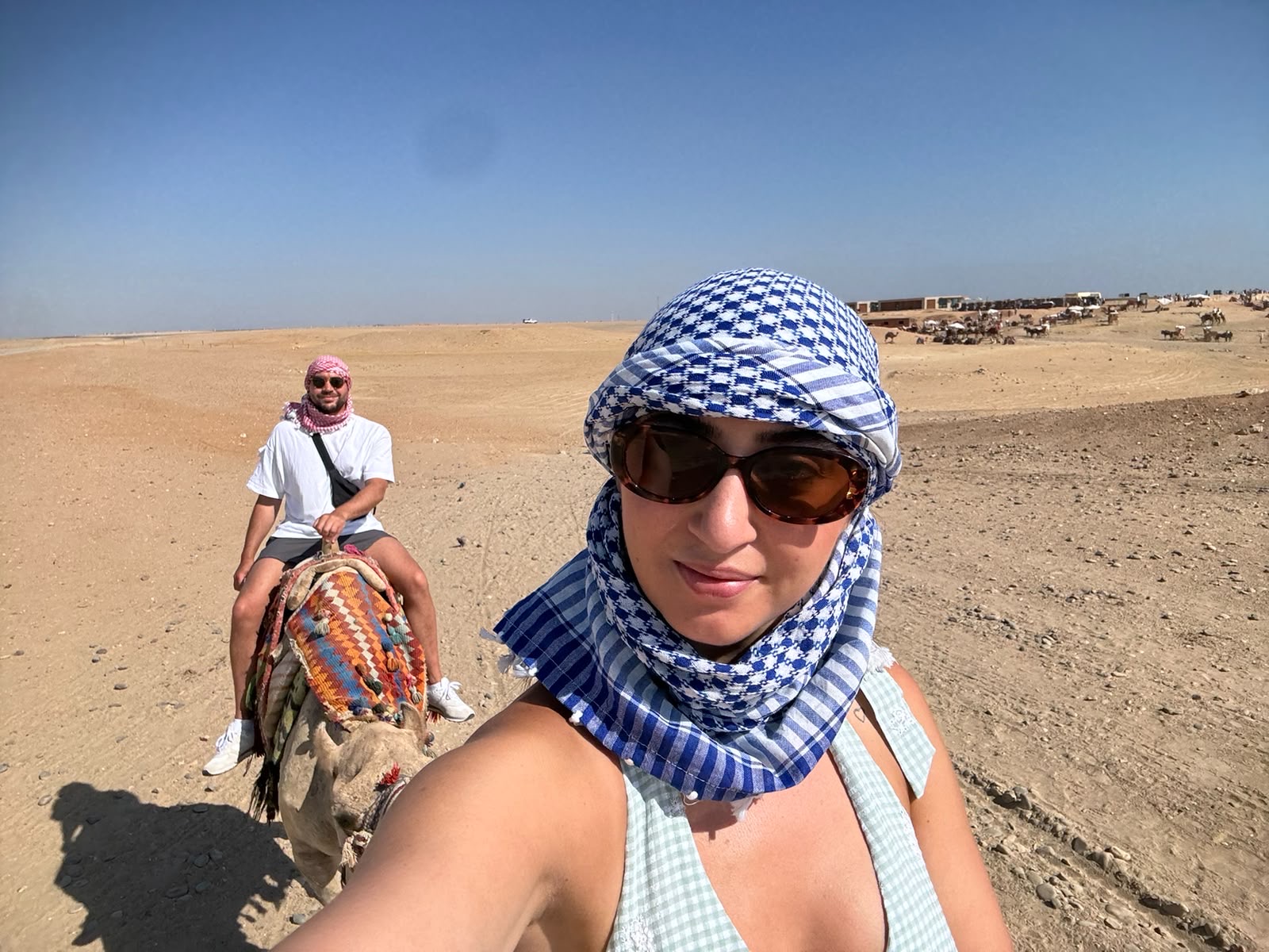 Cole and Claudia riding camels in the desert