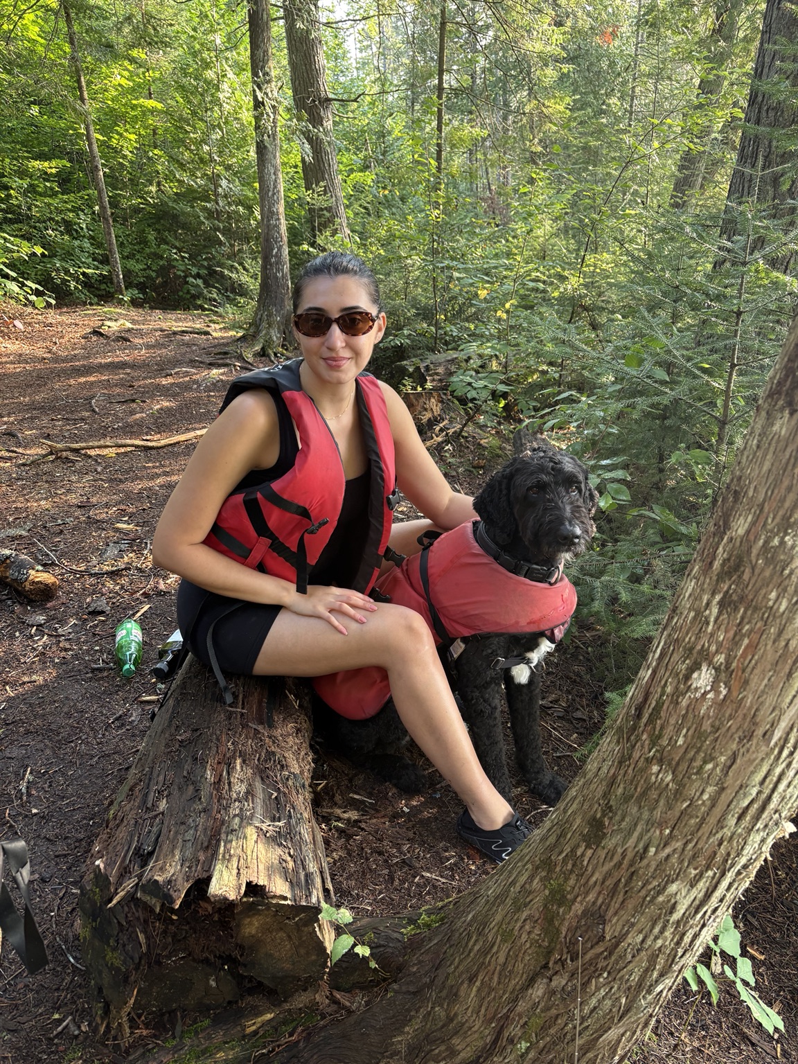 Claudia and their dog resting in the woods
